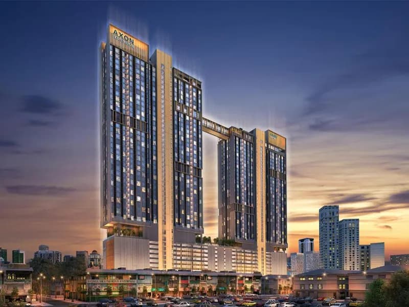 AXON residential towers at dusk, mixed-use retail podium
